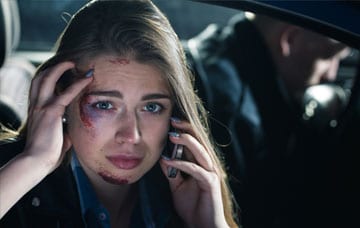 Injured woman calling on mobile after the accident